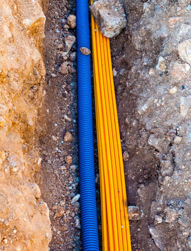 Cable duct for optical fibers and corrugated tube for underground telephone cables in a trench