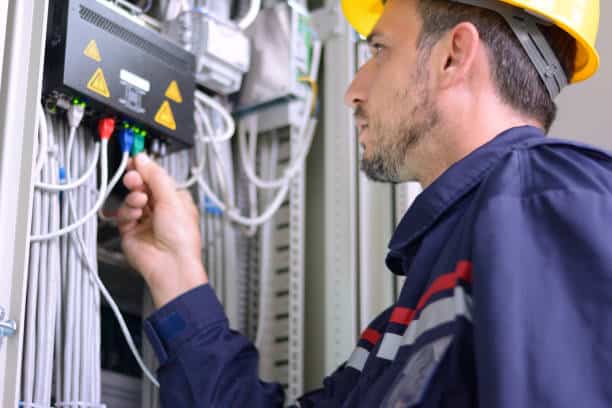 Engineer inspecting cabling connection in electrical room